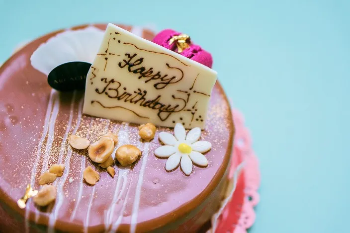 ナッツやお花が飾られた上品なチョコレートホールケーキ。