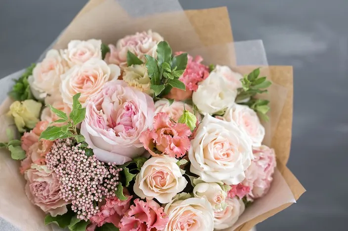 淡いピンクと白のバラをメインにしたボリュームのある花束。