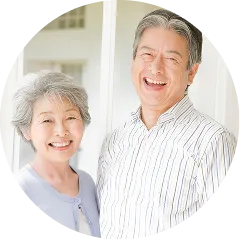 晴れやかな笑顔で並ぶシニアのご夫婦。