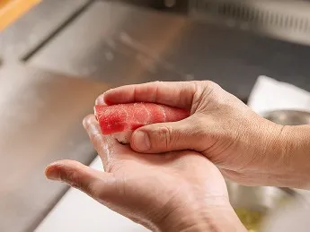 新鮮なマグロを素早く握り、極上の一貫に仕上げる職人の手元