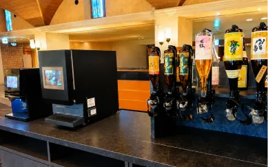 地酒やソフトドリンクのディスペンサーが並ぶセルフドリンクバー
