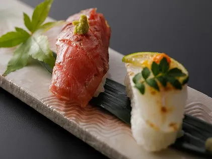 笹の葉の上に上品に並べられた, 艶やかなマグロと白身魚のにぎり寿司