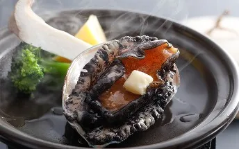 陶板で焼かれる、バターが乗ったアワビの踊り焼き