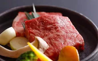 板に並んだ、厚切りで霜降りの和牛生肉と付け合わせの野菜