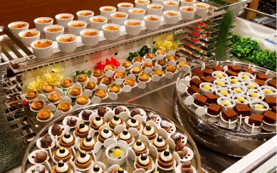 色鮮やかなフルーツタルトや苺のホールケーキ。パティシエ特製の華やかなデザートが並ぶ様子。