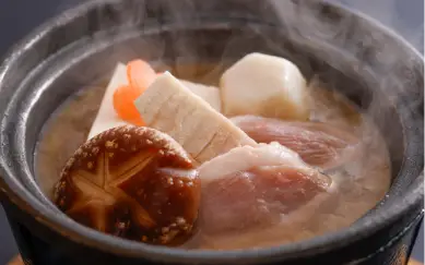 温かい小鍋で煮込まれる、鴨肉やしいたけ、すだれ麩などの加賀の伝統料理「治部煮」。