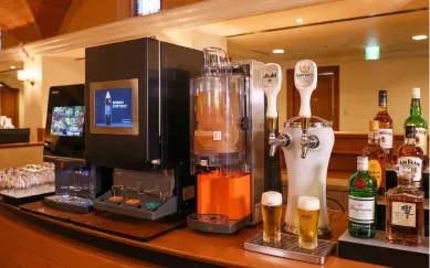 自動ビールサーバーがグラスに黄金色のビールを注ぐ様子。