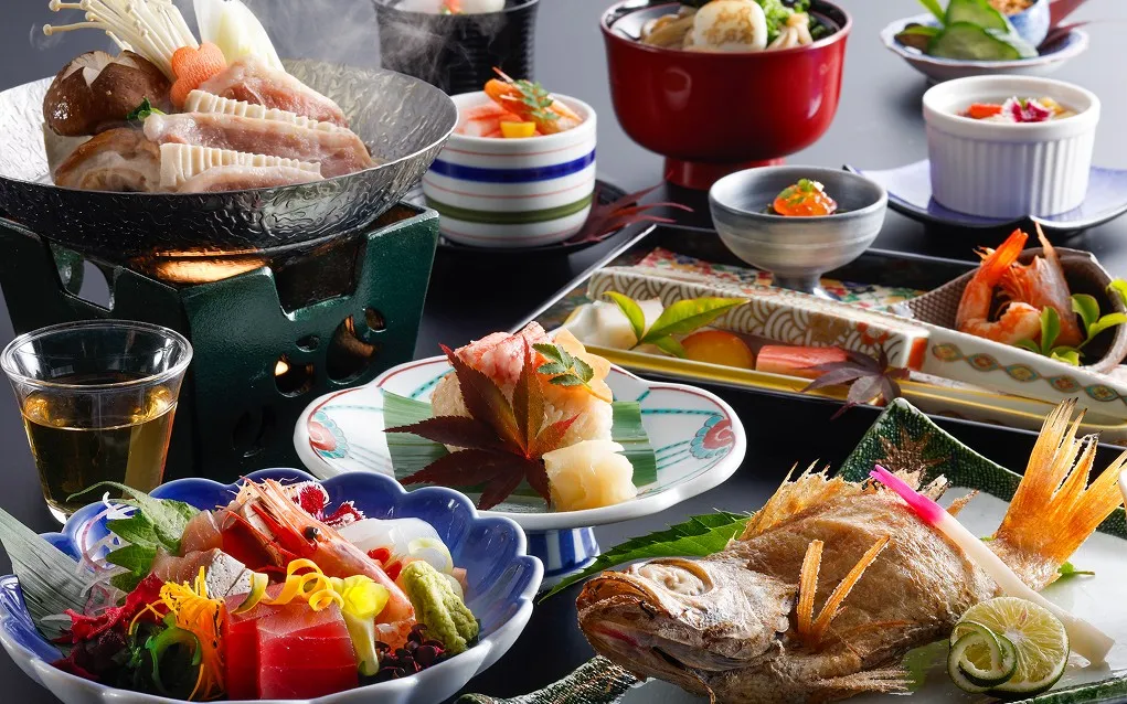鮮やかな刺身の盛り合わせや、香ばしく焼かれた魚、湯気が立ち上る陶板焼きなど、器と盛り付けが際立つ季節の極上会席。