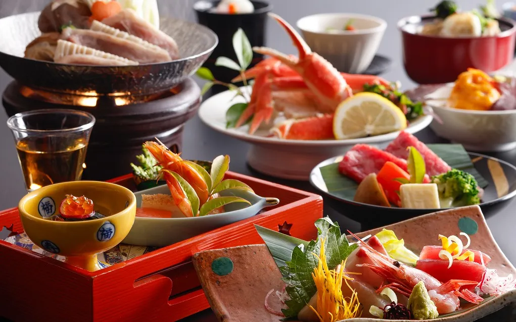 朱色や黄色の器、鮮やかな魚介や野菜が食卓を彩る、北陸の旬を詰め込んだ彩り豊かな極上会席。