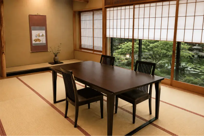 窓から美しい日本庭園を望む、和紙障子に囲まれた落ち着いた佇まいの和室会食場。