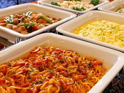 スパゲッティやポテトサラダなど、色とりどりの温かい料理が並ぶビュッフェコーナー。