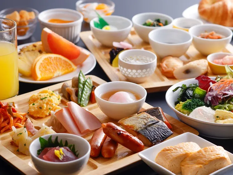 和洋の小鉢やパン、フルーツなど多彩な料理が食卓に広がる、彩り豊かな朝食ビュッフェ。