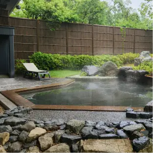 美しい緑の庭園を眺めながら入浴できる、屋根付きの広々とした露天風呂。