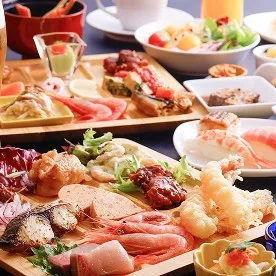 舟盛りや海老など、色とりどりの料理が並ぶ華やかなビュッフェの食卓。