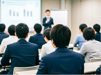 会議室で講演を聞くビジネスパーソンの後ろ姿