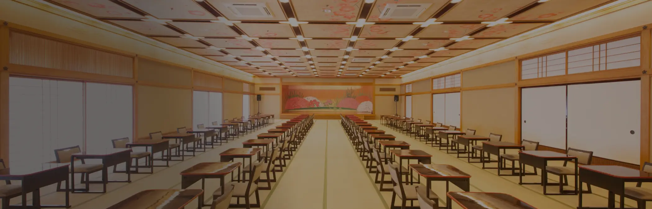 煌びやかな金屏風を背にした、整然と並ぶ御膳と座椅子が印象的な大宴会場の風景