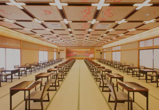 煌びやかな金屏風を背にした、整然と並ぶ御膳と座椅子が印象的な大宴会場の風景