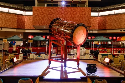 大きな和太鼓と提灯の装飾がある、広々としたイベントスペース。