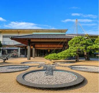 青空と松の木に彩られた和モダンな別邸エントランス外観